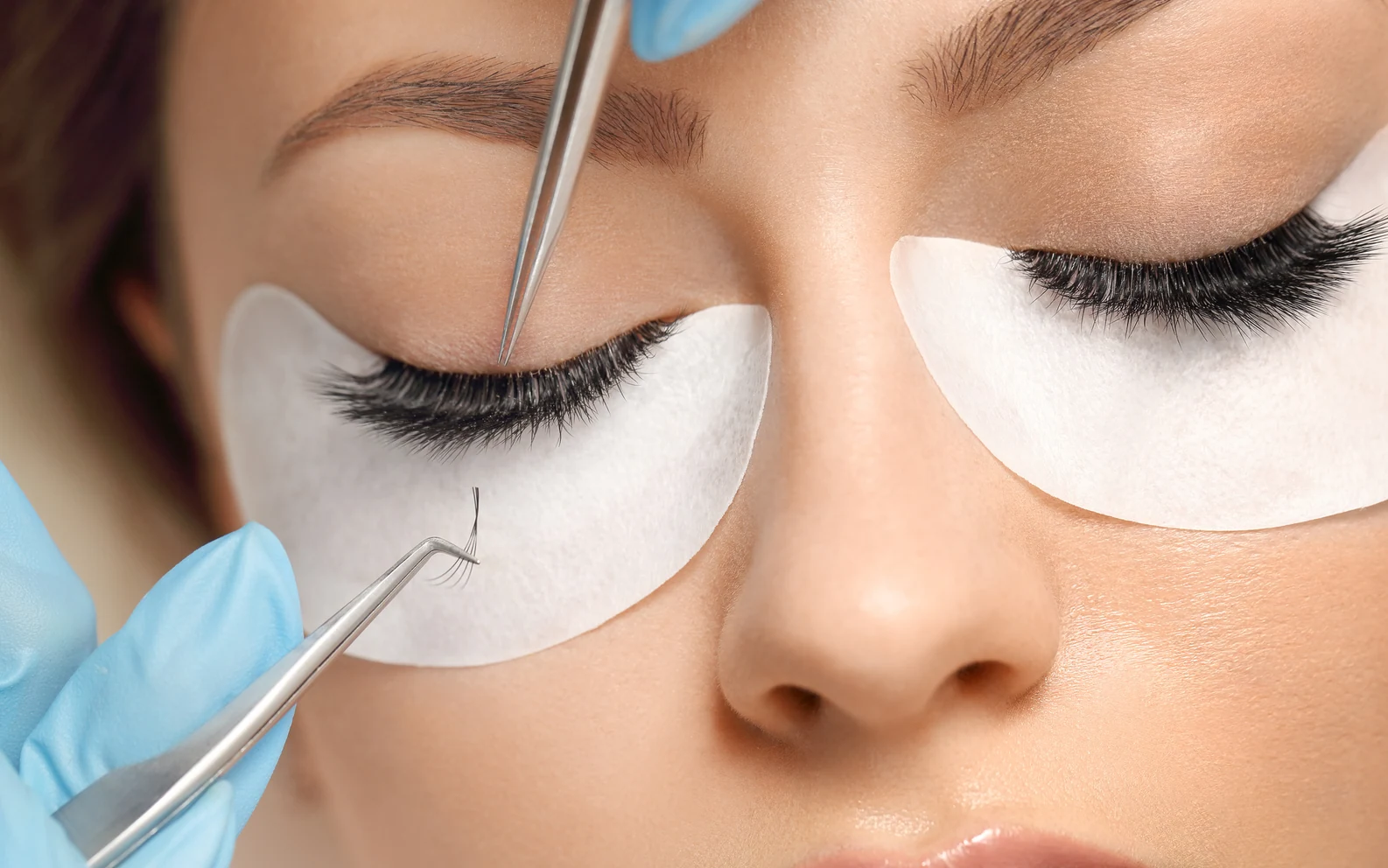 Echte Nahaufnahme einer professionellen Wimpernverlängerung während der Behandlung.